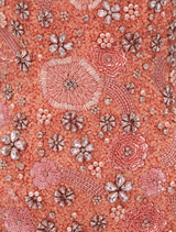 A peach-colored Francesca flower gown displayed on a mannequin, featuring floral embellishments and a flowing silhouette.