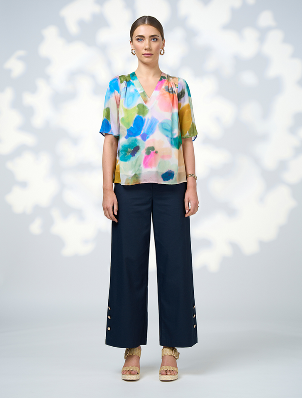 A woman dressed in a colorful top and skirt, featuring the Free Spirit Top - Multi pattern.