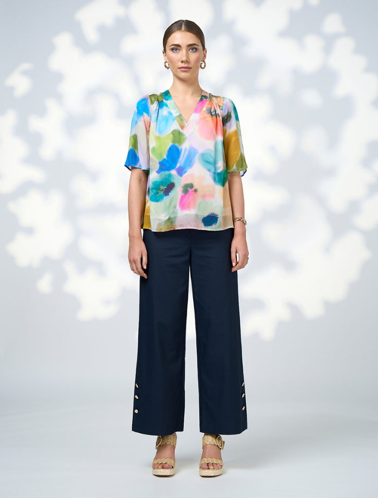 A woman dressed in a colorful top and skirt, featuring the Free Spirit Top - Multi pattern.