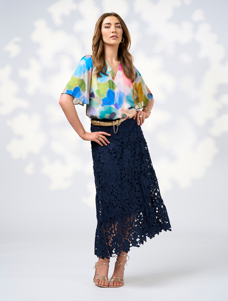 A woman in a bright, multi-colored outfit, highlighting the Free Spirit Top - Multi style.