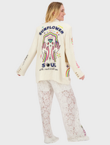  A woman dressed in a white blazer with beautiful embroidered designs, highlighting her fashion sense.
