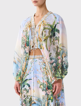 Sculptural silk blouse with lace-up front and blouson sleeves, featuring a dreamlike lilac print and custom tassel trim.