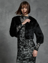 Black fur bolero jacket displayed on a hanger, showcasing its luxurious texture and elegant design.