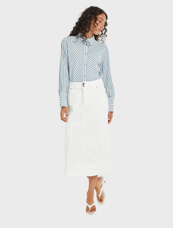 A model poses in a blue and white striped shirt paired with a white skirt, showcasing a stylish summer outfit.