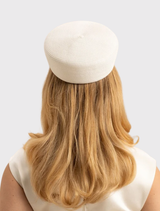 Contemporary ivory white pillbox hat by Morgan & Taylor, designed for stylish events with a classic, minimalist aesthetic.