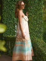 A stylish dress in warm sunset tones, adorned with a bow at the waist, ideal for special occasions.