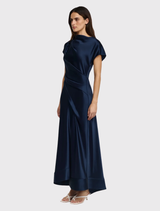 The Glatton Maxi Dress in Sapphire features a sleek design with a lustrous finish, perfect for wedding guest attire.
