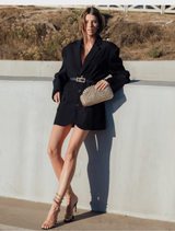 Elegant gold clutch bag made from woven material, featuring a sophisticated texture and design.