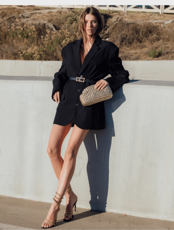 Elegant gold clutch bag made from woven material, featuring a sophisticated texture and design.