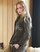 The Seam A Little Seam Jacket in gravel, featuring a sleek silhouette and contemporary style, hanging against a neutral background.