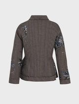 The Seam A Little Seam Jacket in a gravel hue, emphasizing its fashionable style, is showcased on a simple hanger.