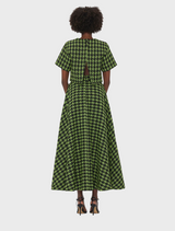 Back view of a woman in a green and black checkered dress, showcasing the dress's pattern and silhouette.