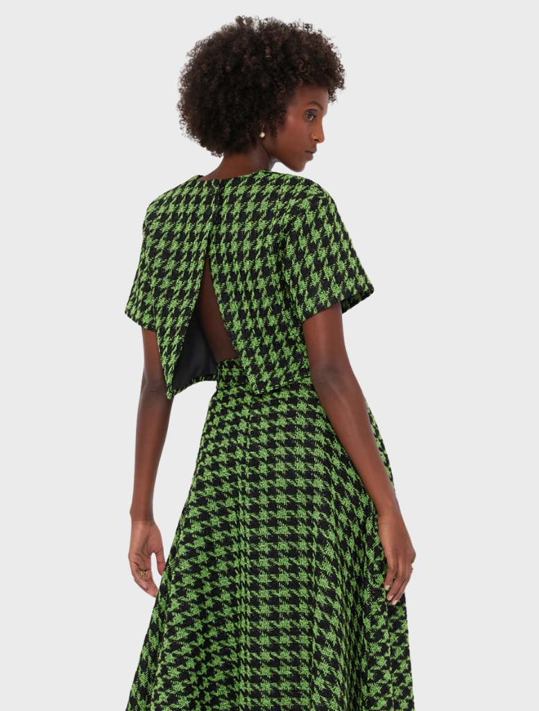 Back view of a woman in a green and black houndstooth dress, showcasing the unique pattern and silhouette.