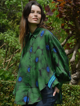 A vibrant green shirt featuring a floral pattern and the phrase "Living The Dream" in bold letters.