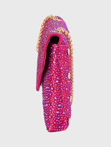 A fashionable fuchsia Hattie Crystal Bag, featuring crystal accents, a magnetic closure, and a shoulder chain, is tailored for elegant evening attire.