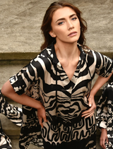 Elegant black and stone dress with a contemporary silhouette, perfect for both casual and formal events.