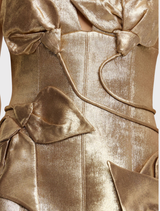 Form-fitting gold mini dress with spaghetti straps and sculptural petal overlay, fully lined with a back zip closure.