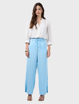 Ice blue pants designed with flattering side seams, tucks, and a waist tie at the lower edge of the waistband.