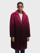 A stylish coat in ice cream pink, hanging against a neutral background, highlighting its color and texture.