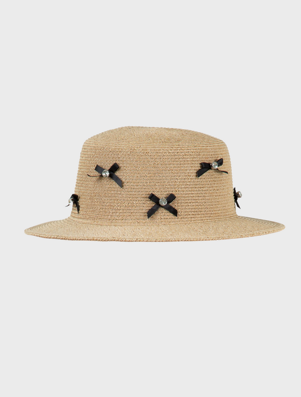 A straw hat adorned with decorative bows, showcasing a stylish and playful design.