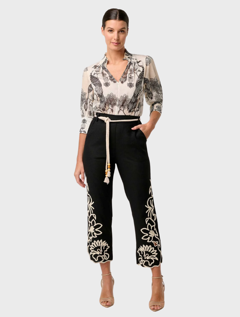 Model showcases black and white floral print pants paired with an Oleander Placement Print Cotton Silk blouse in Imperial Stone.