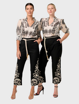 Two women wearing black and white floral print pants, showcasing the Oleander Placement Print Cotton Silk Blouse in Imperial Stone.