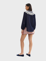 Elegant indigo denim blouse adorned with delicate lace accents, perfect for casual or semi-formal occasions.