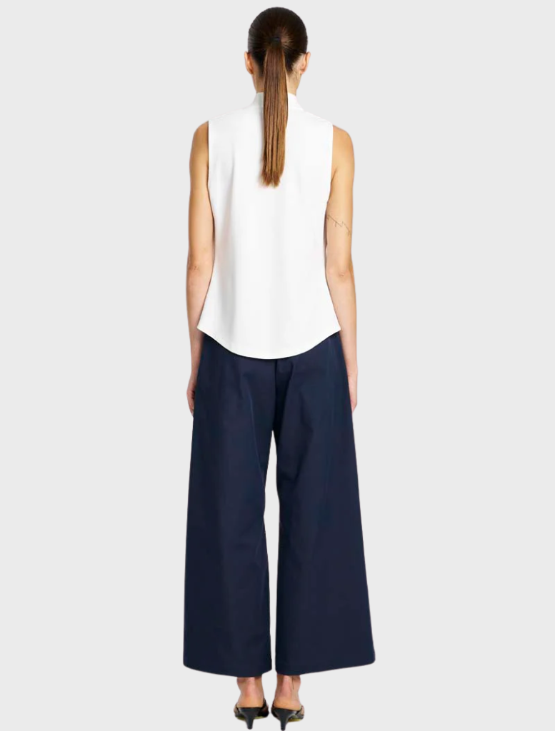A pair of indigo suit pants hanging, featuring a sleek design and crisp lines, ideal for formal occasions.
