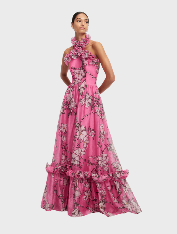 Elegant pink magnolia print maxi dress featuring a halterneck and ruffled accents, perfect for special occasions.