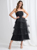 Elegant black and gold tiered dress by Ivana, featuring multiple layers and a sophisticated silhouette.