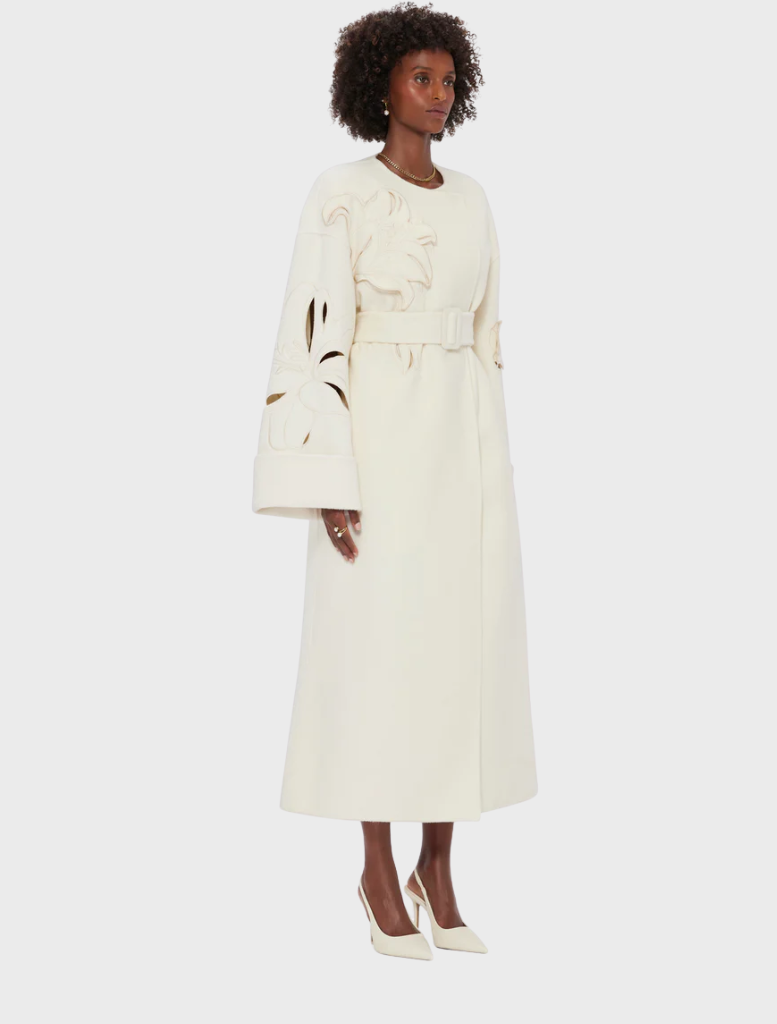 White wool coat with long sleeves and a belt, perfect for stylish warmth in cooler weather.