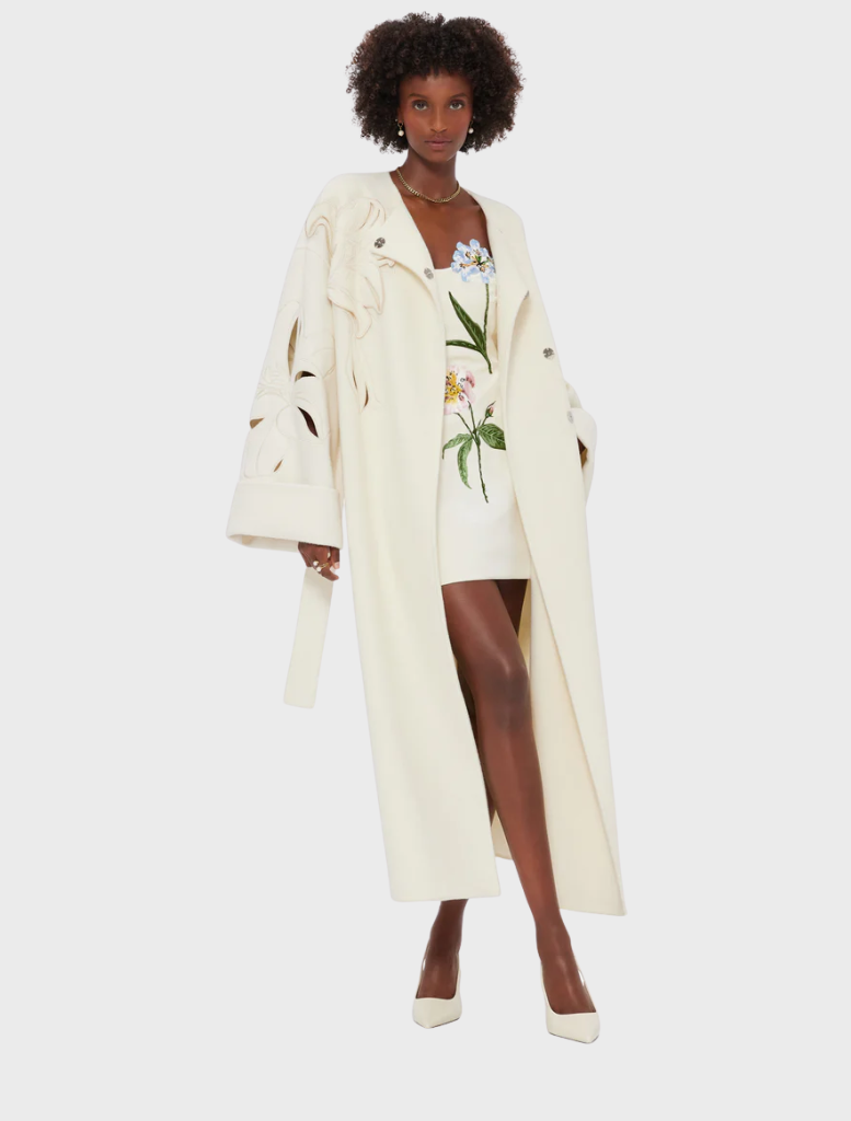 White wool coat with long sleeves and a belt, perfect for stylish warmth in cooler weather.