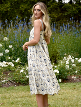 The model showcases a blue and white floral print dress, highlighting its delicate patterns and stylish fit.