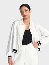 A person wearing a white and navy jacket over a black top.