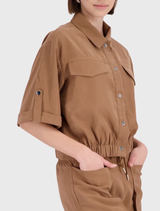 Model wearing a mocca jacket with ¾ sleeves, featuring a shirt collar and cuffed sleeves, showcasing a modern style.