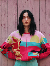 Pink jacquard bomber jacket with bold geometric patterns, designed by IVKO Woman, showcasing urban-inspired summer colors.