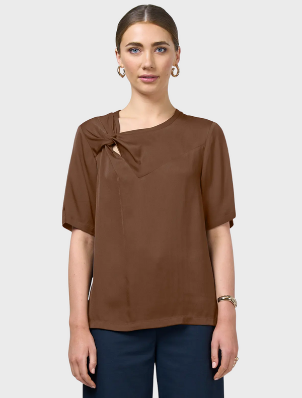 Brown top featuring an asymmetric neckline, showcasing a unique and stylish design.