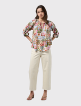 V-neck printed blouse featuring a self-tie collar, blouson sleeves, and contrast tabs, inspired by Sri Lanka's Ceylon collection.