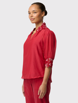 Lightweight Jardin Cotton Silk Blouse in Dahlia Red, with embroidered details, relaxed fit, and shirred sleeve cuffs.