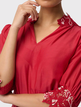 Sophisticated Jardin Blouse in Dahlia Red, constructed from a cotton-silk mixture, featuring an embroidered neckline and gathered sleeve cuffs.