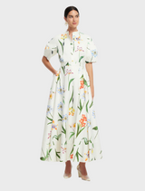 A model showcases a white floral print dress, complemented by a white blouse and a tailored white blazer.
