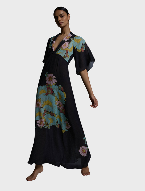 Model wearing a black floral print dress named Julia Maxi Dark Ink Floral, showcasing vibrant floral patterns