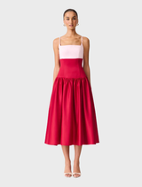 A June gown featuring a white top with a red and pink patterned skirt.