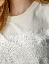 Soft cream t-shirt designed with a lace front overlay, providing a stylish and feminine accent to a casual wardrobe staple.