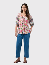 Elegant button-up blouse in silk white, showcasing a bold border print on sleeves and an elasticated neckline for easy wear.