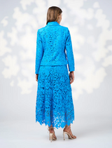 A woman dressed in blue, complemented by a jacket shows backside
