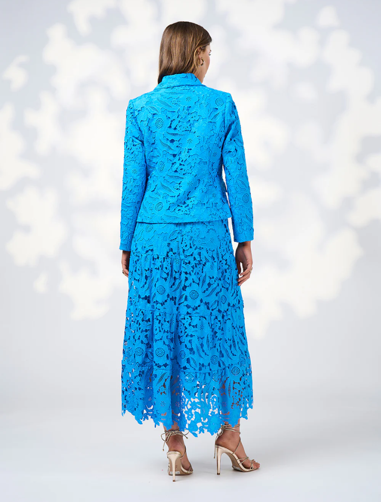A woman dressed in blue, complemented by a jacket shows backside
