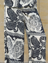 Black kick pleat pants with a sleek design, featuring a stylish pleat that adds sophistication to any outfit.