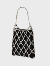 Elegant black and white purse, the Kit Crystal Cage Bag, featuring a chic chain strap for added sophistication.