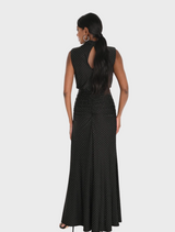 Stylish black polka dot dress with a cinched waist and flowing skirt, presented on a hanger in a softly lit environment.